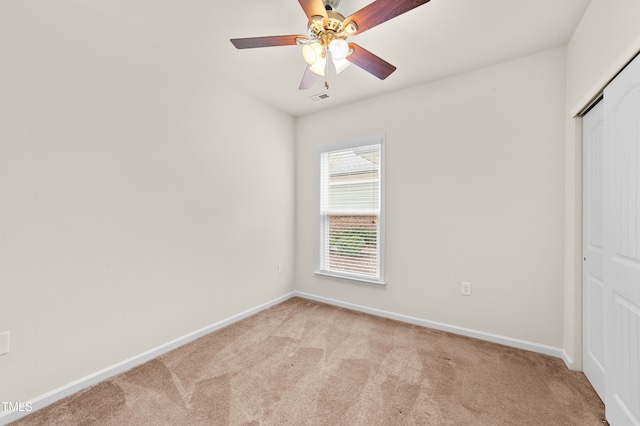 unfurnished bedroom featuring a closet, ceiling fan, and light colored carpet