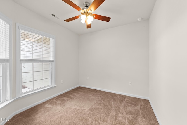 spare room with ceiling fan, light colored carpet, and plenty of natural light