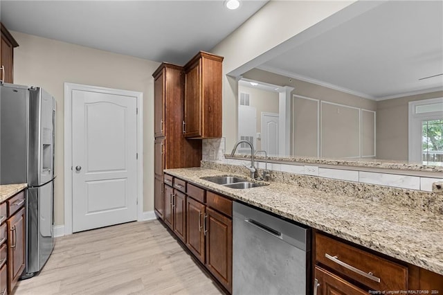 kitchen with light wood-type flooring, decorative backsplash, stainless steel appliances, sink, and ornamental molding