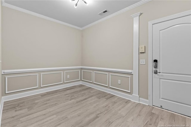 empty room with ornamental molding and light hardwood / wood-style floors