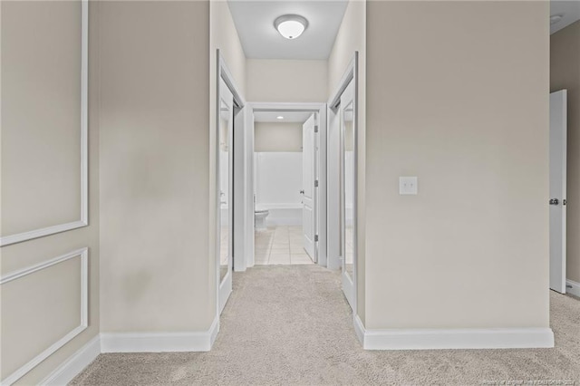 hall featuring light colored carpet