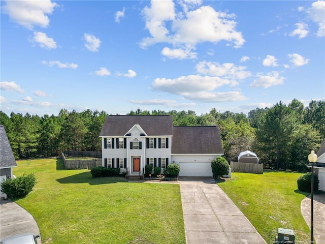 colonial home with a front yard and a garage