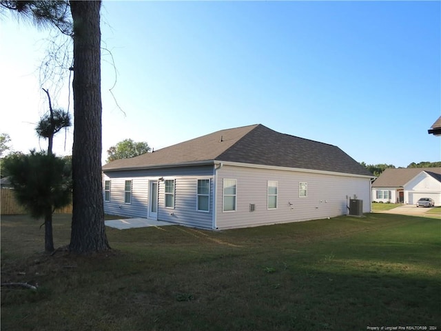 view of side of property featuring central air condition unit, a yard, and a patio area