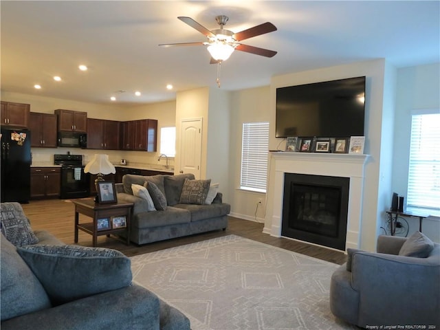 living room featuring light hardwood / wood-style flooring and ceiling fan