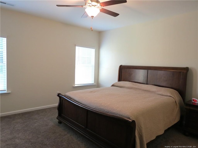 carpeted bedroom featuring multiple windows and ceiling fan