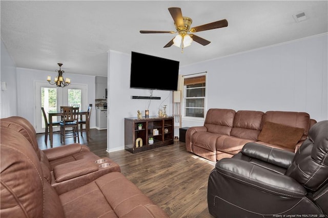 living room featuring ceiling fan with notable chandelier, crown molding, and dark wood-type flooring