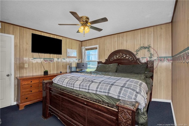 carpeted bedroom featuring a textured ceiling, ornamental molding, wooden walls, and ceiling fan