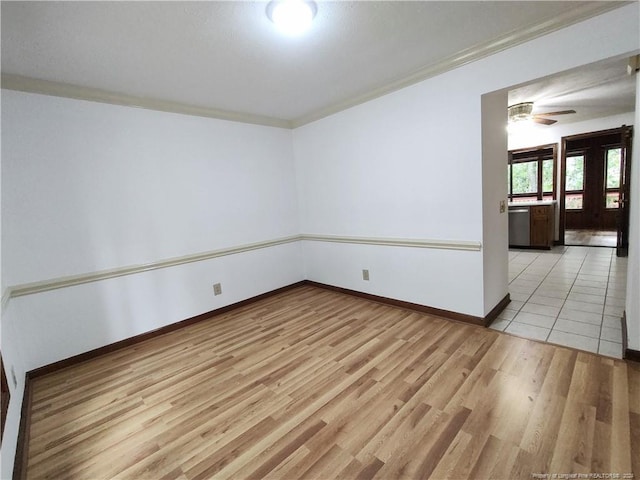 empty room with ceiling fan, light wood-type flooring, and ornamental molding