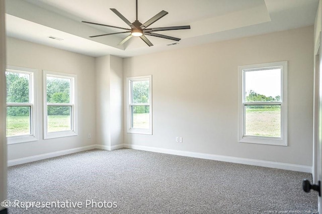 carpeted empty room featuring a wealth of natural light and ceiling fan