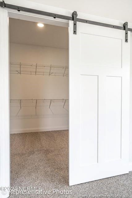 walk in closet with a barn door