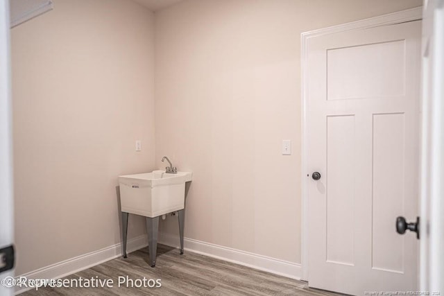 laundry area with wood-type flooring