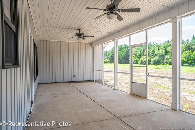 unfurnished sunroom featuring ceiling fan and a wealth of natural light