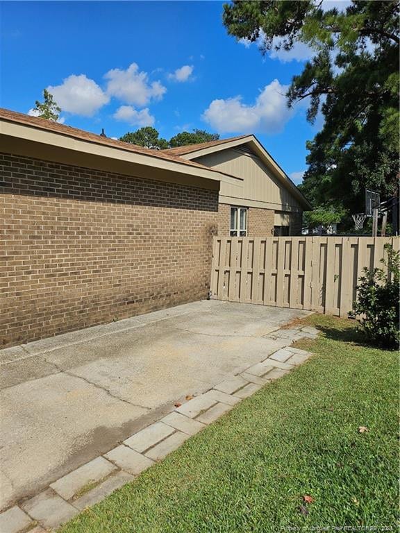 view of side of property featuring a lawn and a patio area