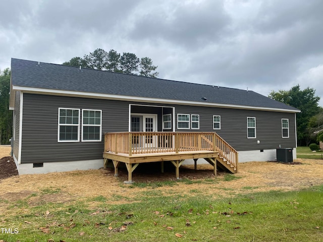 back of property with a yard, a wooden deck, and central air condition unit