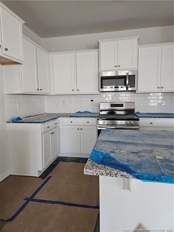 kitchen featuring white cabinets, backsplash, and appliances with stainless steel finishes