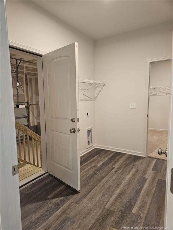 washroom featuring electric dryer hookup, dark wood-style flooring, laundry area, and baseboards