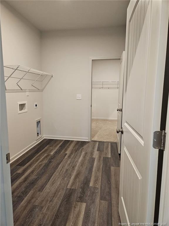 clothes washing area with dark wood-style floors, hookup for an electric dryer, baseboards, hookup for a washing machine, and laundry area