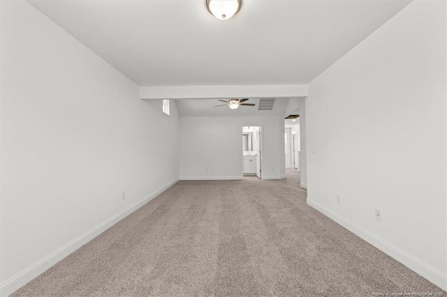 empty room featuring light carpet, a ceiling fan, visible vents, and baseboards