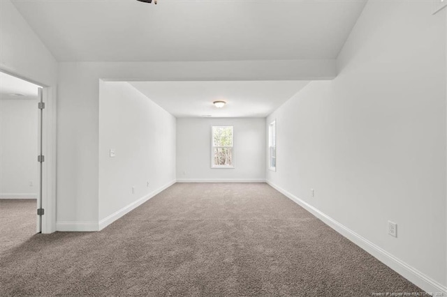 unfurnished room featuring baseboards and carpet flooring