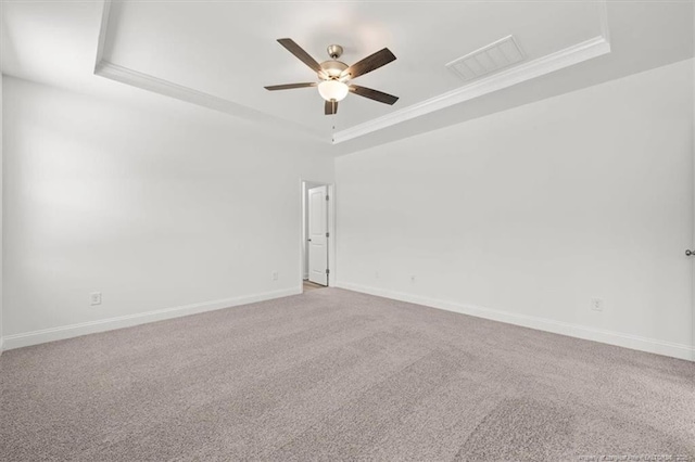 empty room featuring baseboards, visible vents, a raised ceiling, ceiling fan, and carpet floors