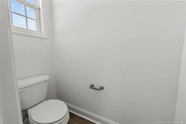 bathroom featuring toilet, baseboards, and wood finished floors