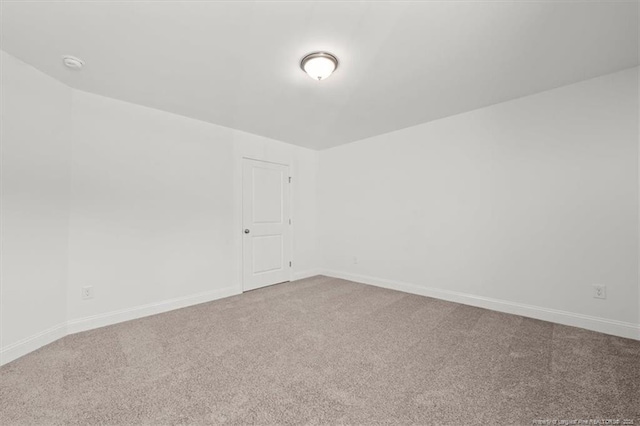 spare room featuring baseboards and carpet flooring