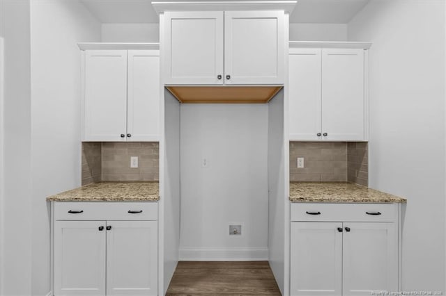 kitchen featuring light stone counters, wood finished floors, and white cabinetry