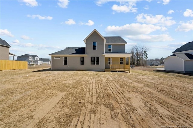 rear view of house featuring fence