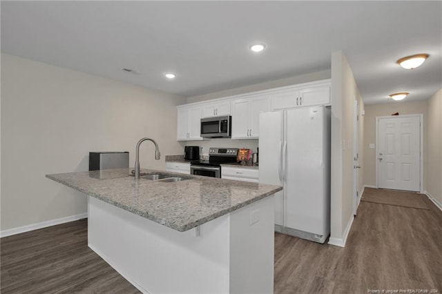 kitchen with an island with sink, dark hardwood / wood-style floors, stainless steel appliances, sink, and white cabinetry