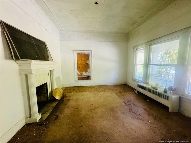 unfurnished living room with a fireplace and radiator heating unit