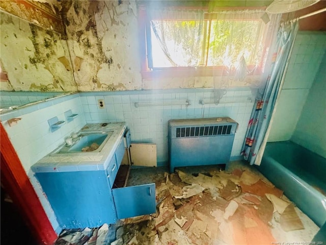 bathroom featuring radiator heating unit and tile walls