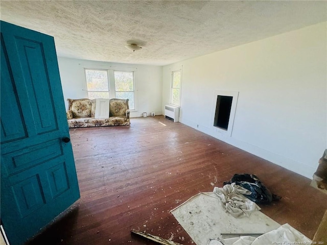 interior space featuring radiator heating unit, dark hardwood / wood-style flooring, and a textured ceiling