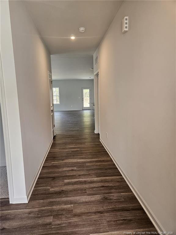 corridor with visible vents, baseboards, recessed lighting, and dark wood-style flooring