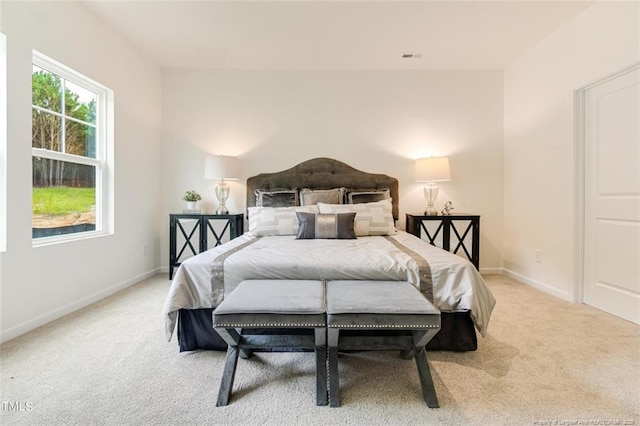 bedroom featuring light carpet and baseboards