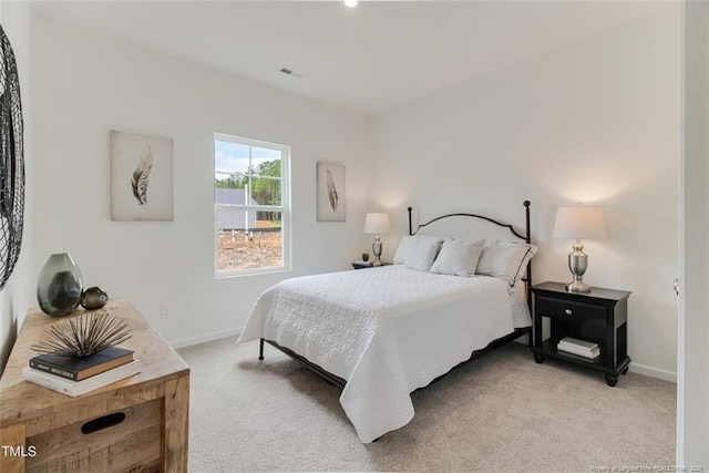 bedroom with visible vents, baseboards, and light carpet