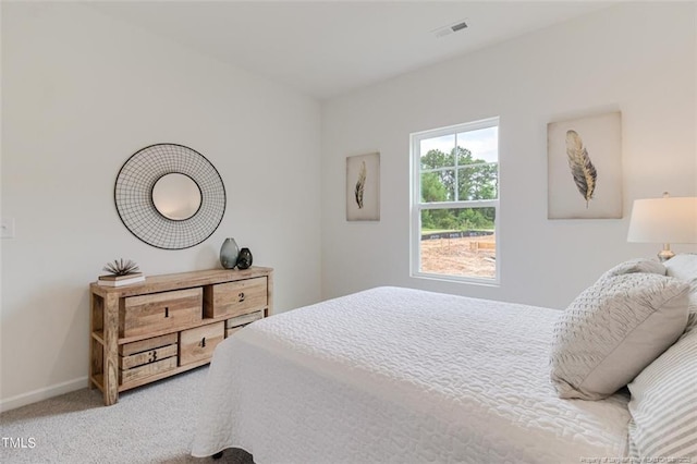 carpeted bedroom featuring baseboards and visible vents