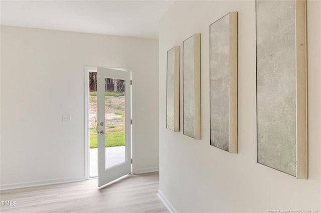 doorway featuring french doors, baseboards, and wood finished floors