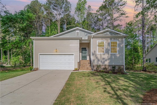 view of front facade with a garage, driveway, and a yard