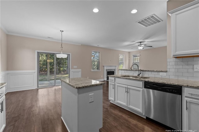 kitchen with a wealth of natural light, sink, white cabinetry, and stainless steel dishwasher