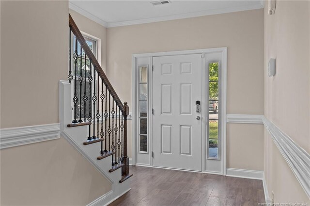 entryway featuring dark hardwood / wood-style floors, ornamental molding, and a wealth of natural light