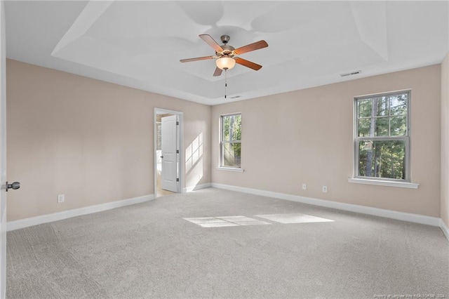 carpeted empty room featuring ceiling fan and a tray ceiling