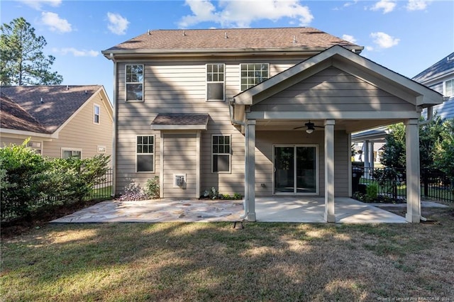 rear view of property featuring ceiling fan, a patio, and a lawn