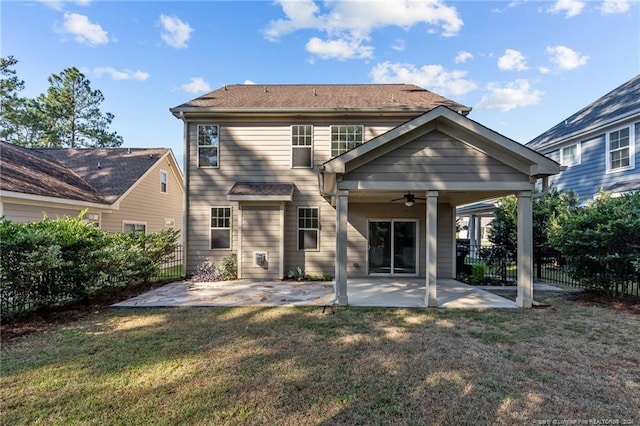 rear view of house with ceiling fan, a lawn, and a patio area