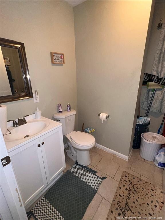 bathroom with vanity, tile patterned flooring, and toilet