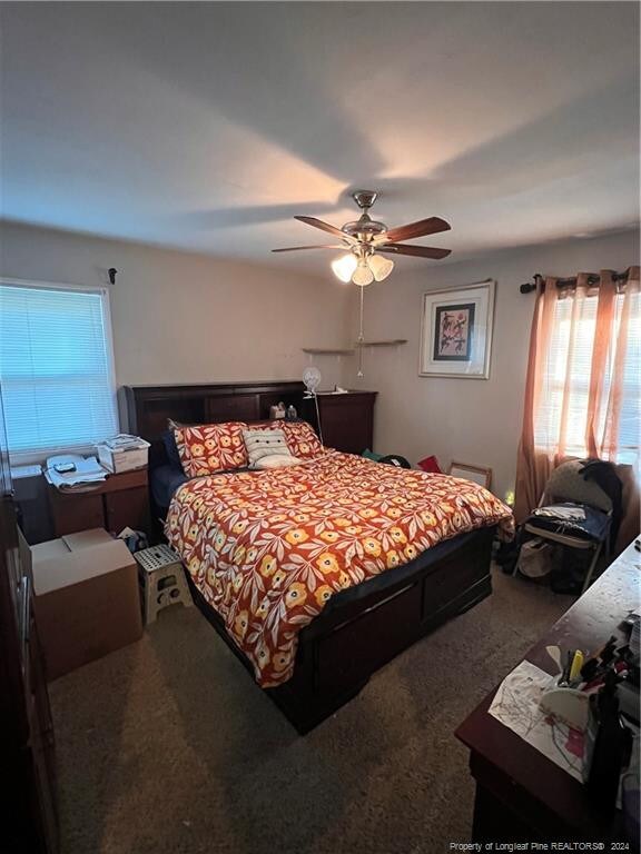 bedroom featuring ceiling fan and carpet