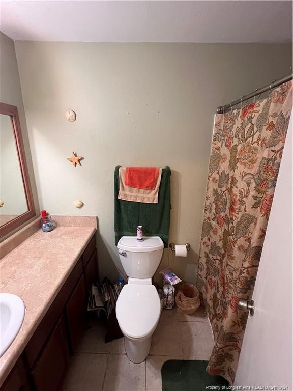 bathroom with vanity, tile patterned flooring, and toilet