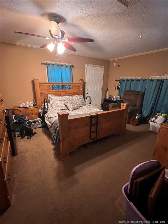 bedroom featuring carpet floors, a textured ceiling, and ceiling fan