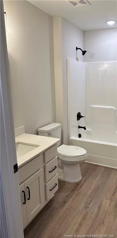 full bathroom featuring vanity, toilet, hardwood / wood-style floors, and shower / bathing tub combination