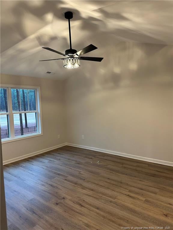 empty room with ceiling fan, lofted ceiling, and dark hardwood / wood-style flooring