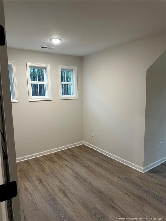 empty room with dark hardwood / wood-style flooring